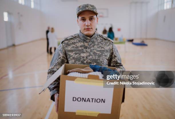 a soldier and donation box - man holding donation box stock pictures, royalty-free photos & images
