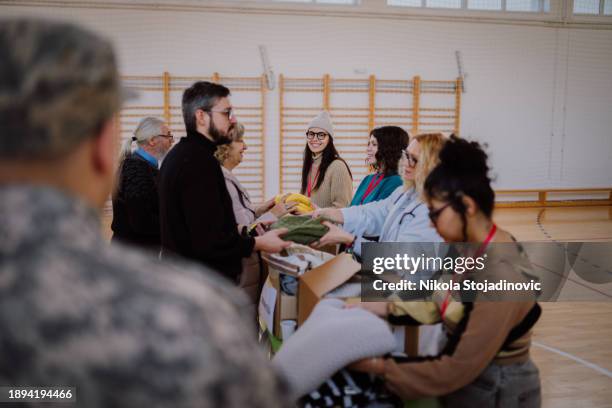 group of multiracial volunteers working in community charity donation center - notunterkunft stock-fotos und bilder