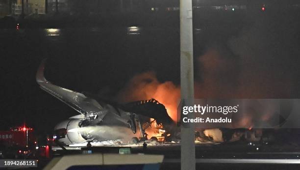 Firefighters intervene in the burning planes after a Japan Airlines plane and an aircraft of Japan Coast Guard collided at Tokyo airport on January...