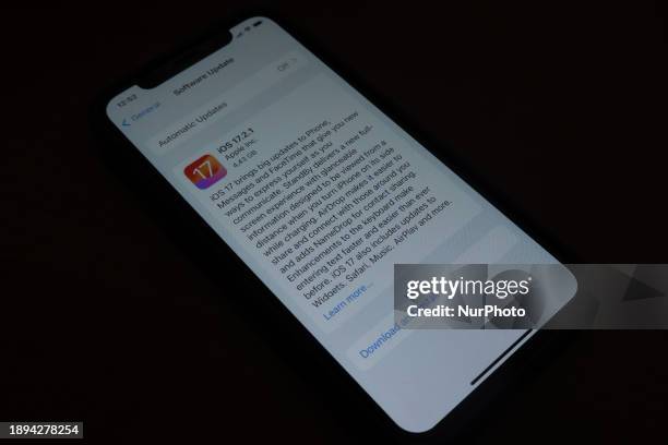 IOS17.2.1 download page on a smartphone on a dark background is seen in L'Aquila, Italy, on January 2nd, 2024. A few days after the release of the...