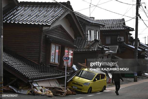 Car is seen trapped under a collapsed house in Wajima, Ishikawa prefecture on January 2 a day after a major 7.5 magnitude earthquake struck the Noto...