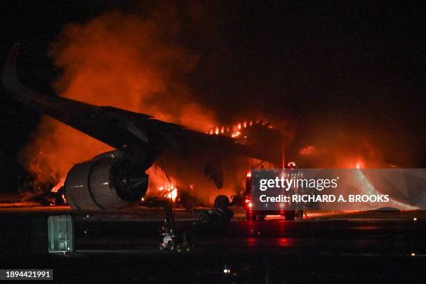 Japan Airlines passenger plane is seen on fire on the tarmac at Tokyo International Airport at Haneda on January 2, 2024. A Japan Airlines plane was...