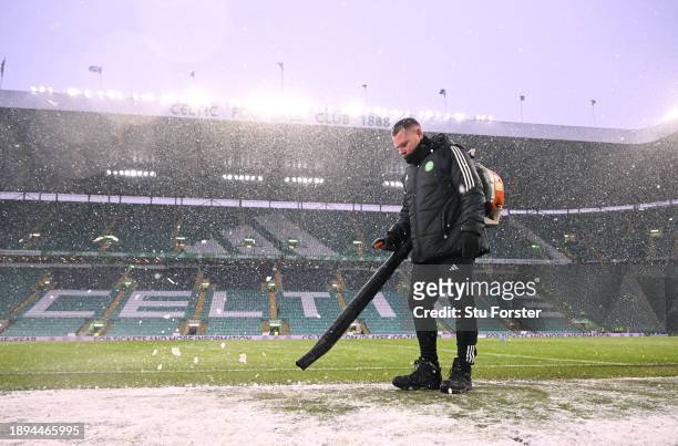 Groundsman clears the snow prior to the Cinch Scottish Premiership match between Celtic FC and Rangers FC at Celtic Park Stadium on December 30, 2023...