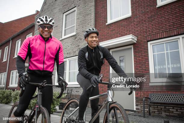two black friends on racing cycles in a dutch neighbourhood - training wheels stock pictures, royalty-free photos & images