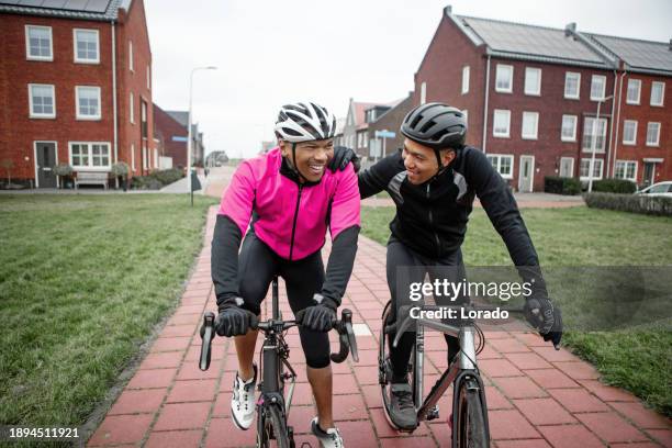 dos amigos negros en bicicletas de carreras en un barrio holandés - evento de ciclismo fotografías e imágenes de stock