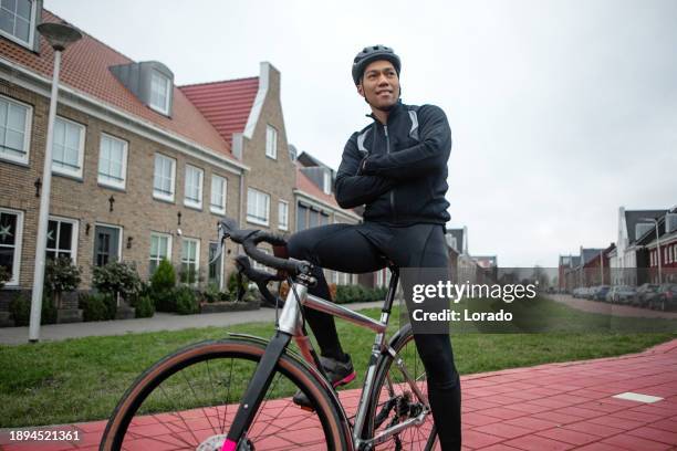 a black man exercising on a racing cycle in a dutch neighbourhood - training wheels stock pictures, royalty-free photos & images