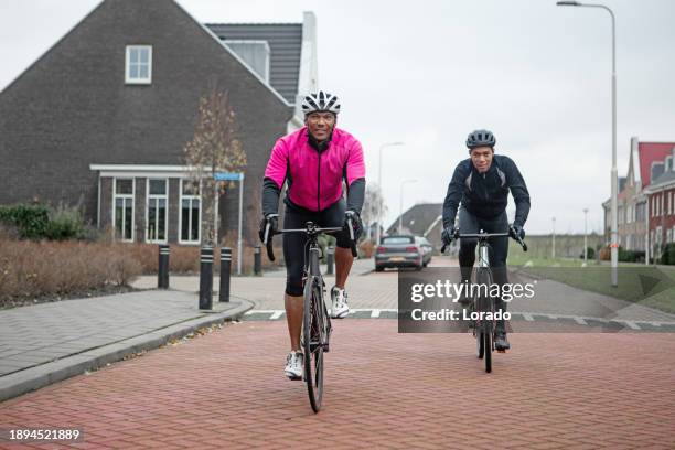 two black friends on racing cycles in a dutch neighbourhood - training wheels stock pictures, royalty-free photos & images