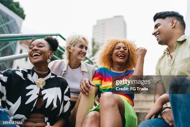 amigos lgbtqia+ hablando sentados en una escalera al aire libre - transgénero fotografías e imágenes de stock