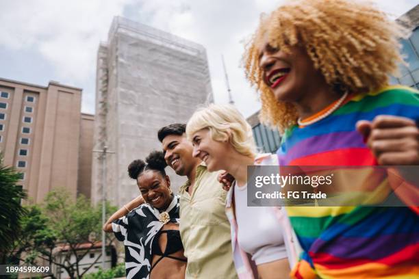 des amis lgbtqia+ discutent et se promènent dans la ville - gay pride photos et images de collection