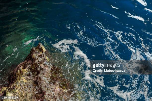 abstract picture sea rock and trasparent deep blue sea waters with sea foam - trasparente stock pictures, royalty-free photos & images