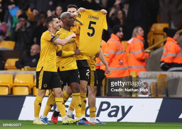Max Kilman of Wolverhampton Wanderers holds up the shirt of Mario Lemina of Wolverhampton Wanderers after scoring their sides first goal during the...