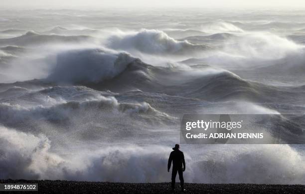 Person looks out towards the waves crashing on the shore in Newhaven on January 2 as Storm Henk was set to bring strong winds and heavy rain across...