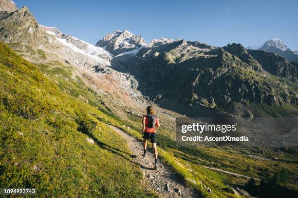 trail runner bounds along mountain trail - mont blanc massif stock pictures, royalty-free photos & images