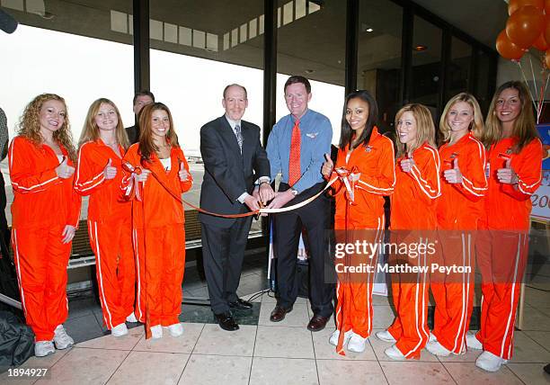 Newark Airport General Manager John Jacoby , Hooters Air Chief Financial Officer Mark Peterson and Hooters Girls cut the ribbon celebrating the...
