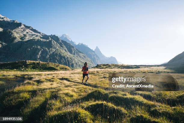 trail runner bounds along mountain trail - mont blanc massif stock pictures, royalty-free photos & images