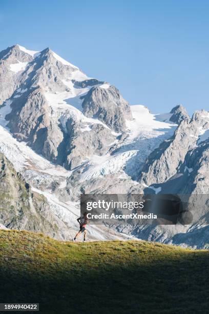 trail runner bounds along mountain trail - mont blanc massif stock pictures, royalty-free photos & images