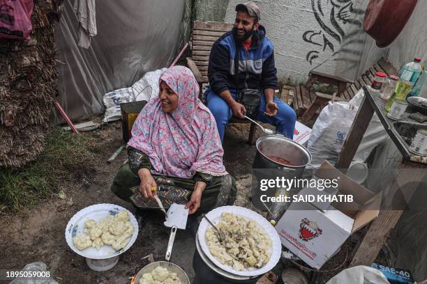 Displaced Palestinians cook a meal inside their shelter at the zoo in Rafah in the southern Gaza Strip, on January 2 where they sought refuge amid...