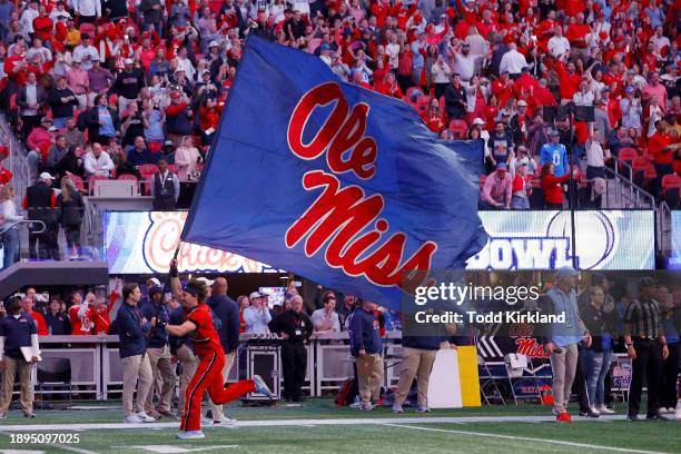 Mississippi Rebels cheerleader waves a flag during the Chick-fil-A Peach Bowl against the Penn State Nittany Lions at Mercedes-Benz Stadium on...