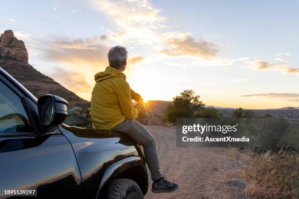 mature man watches sunset from vehicle - adventure stock pictures, royalty-free photos & images