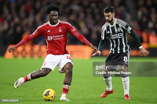 Ola Aina of Nottingham Forest is challenged by Bruno Fernandes of Manchester United during the Premier League match between Nottingham Forest and...