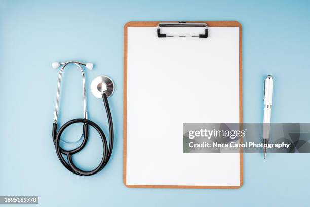stethoscope and clipboard on blue background - tablilla con sujetapapeles fotografías e imágenes de stock
