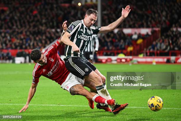 Jonny Evans of Manchester United is tackled by Morgan Gibbs-White of Nottingham Forest during the Premier League match between Nottingham Forest and...