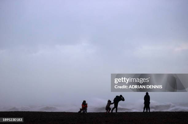People stand in the wind on the beach in Newhaven on January 2 as Storm Henk brought strong winds and heavy rain across much of southern England.