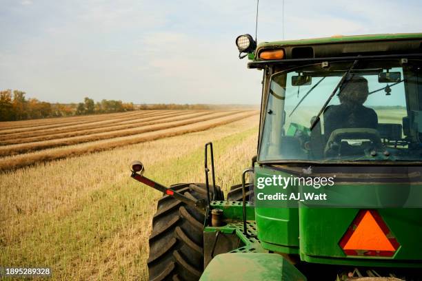 farmer driving tractor on agricultural farm field - tractor stockfoto's en -beelden