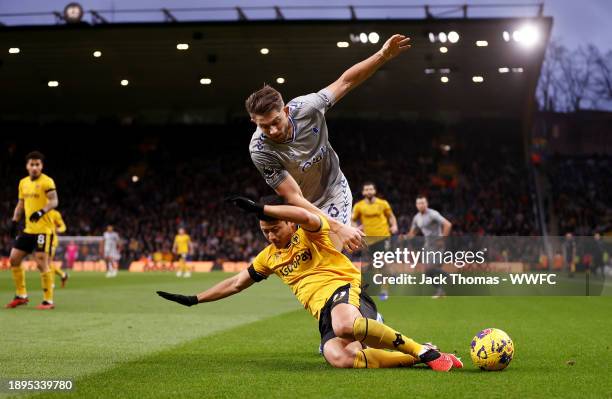 Hee chan Hwang of Wolverhampton Wanderers is challenged by James Tarkowski of Everton FC during the Premier League match between Wolverhampton...