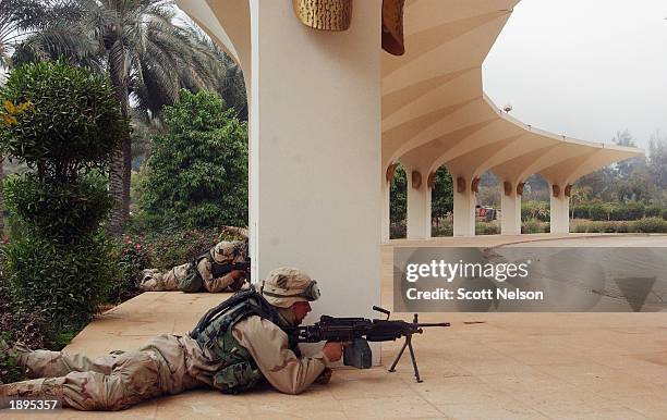 Army 3rd Division 3-7 soldiers take cover in a gunbattle outside the VIP terminal of Baghdad International Airport during a April 4, 2003 dawn...