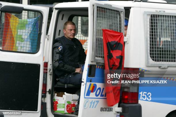 Un fourgon de la police suisse patrouille, le 03 juin 2003 à Genève, arborant un drapeau de la paix et un autre à l'effigie de Che Guevara, lors...