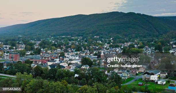 forested mountain behind williamsport, pa at sunset - aerial - jades pa stock pictures, royalty-free photos & images