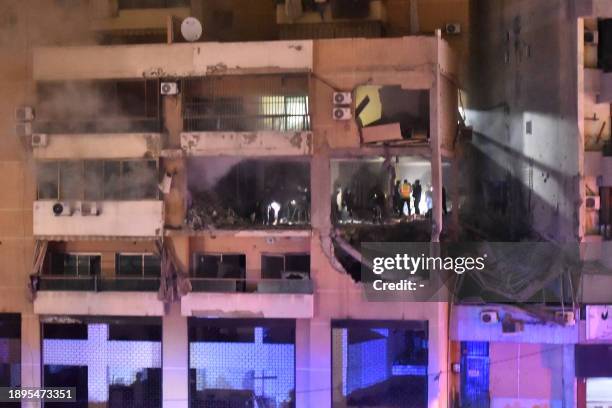 People inspect the site of a strike, reported by Lebanese media to be an Israeli strike targeting a Hamas office, in the southern suburb of Beirut on...