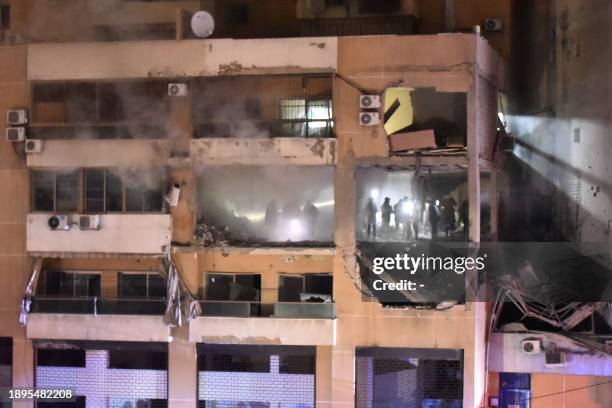 People inspect the site of a strike, reported by Lebanese media to be an Israeli strike targeting a Hamas office, in the southern suburb of Beirut on...