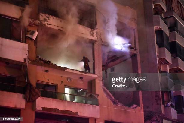 People inspect the site of a strike, reported by Lebanese media to be an Israeli strike targeting a Hamas office, in the southern suburb of Beirut on...