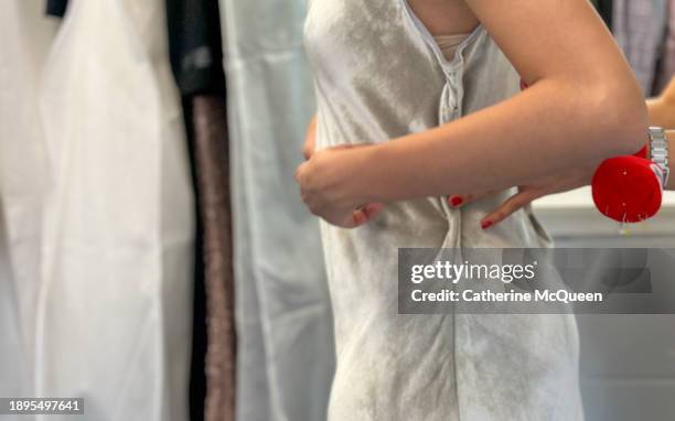 multiracial young woman has dress pinned for alterations - black tie party fancy stock pictures, royalty-free photos & images