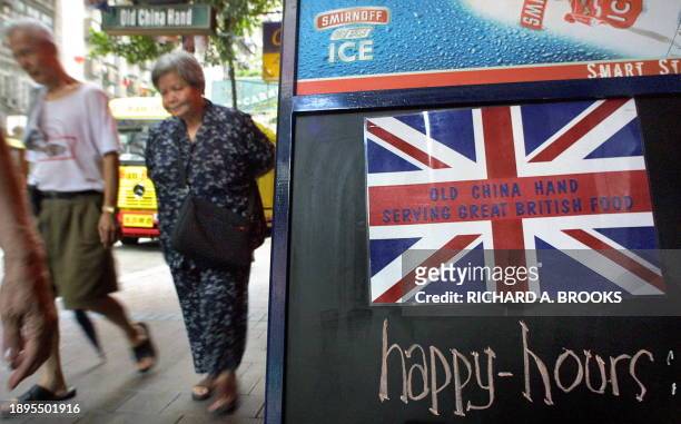 An elderly Chinese couple walk past a British-style pub and restaurant in the Wan Chai district of Hong Kong, 12 July 2003. British Prime Minister...