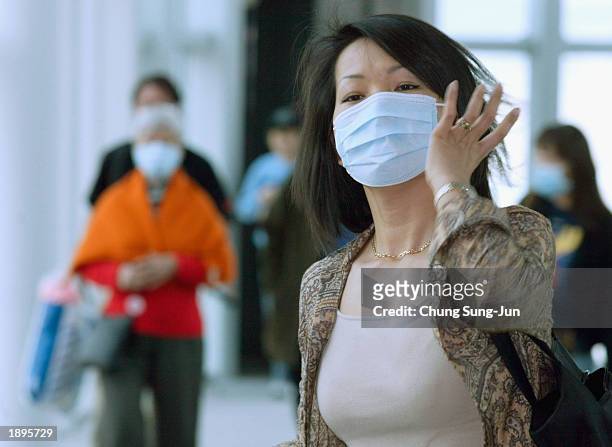 South Koreans and tourists from Hong Kong wear face masks against possible infection of Severe Acute Respiratory Syndrome after arriving at Incheon...