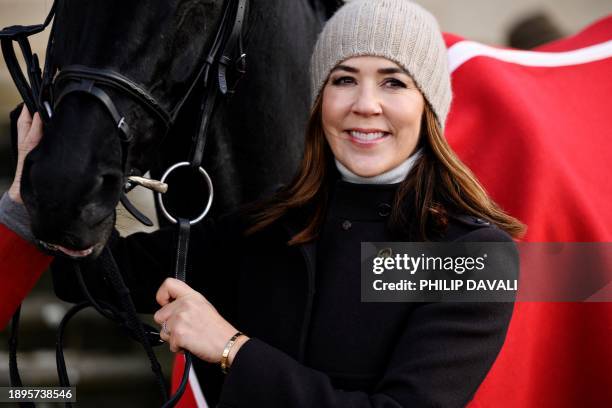 This photo taken on November 7, 2021 shows Crown Princess Mary of Denmark standing with the winner horse Danglo's Top Elan in front of the Hermitage...