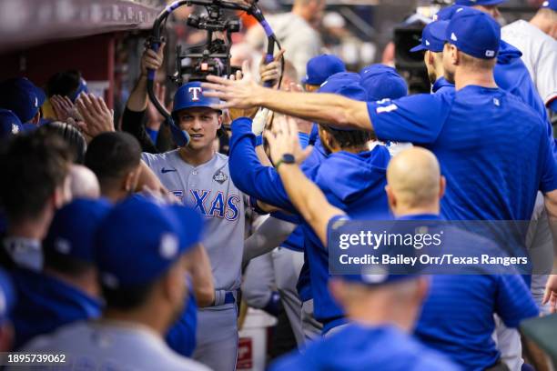 Corey Seager of the Texas Rangers celebrates with teammates in the dugout during Game Four of the World Series against the Arizona Diamondbacks at...