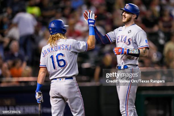 Jonah Heim celebrates with Travis Jankowski of the Texas Rangers after hitting a solo home run in the eighth inning during Game Four of the World...