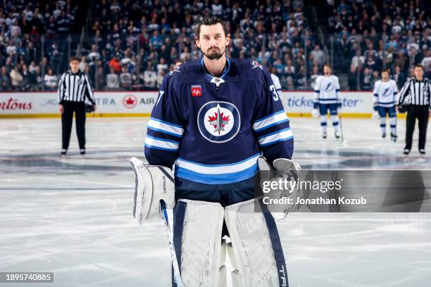 Goaltender Connor Hellebuyck of the Winnipeg Jets looks on as he stands on the ice prior to puck drop against the Tampa Bay Lightning at the Canada...