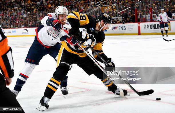 Marcus Pettersson of the Pittsburgh Penguins battles against Anthony Mantha of the Washington Capitals at PPG PAINTS Arena on January 2, 2023 in...