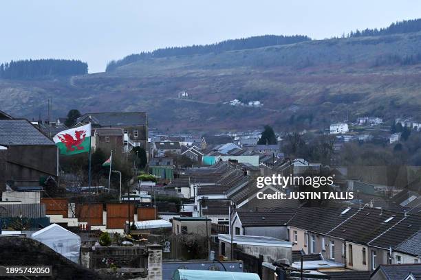 Welsh flag flutters in the wind over the town of Tylorstown near the Tylorstown tip on December 6, 2023 in the Rhondda Valley, south Wales. It was...