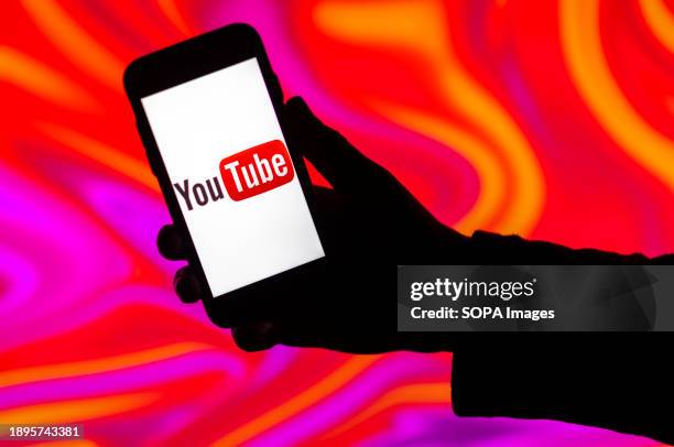 In this photo illustration, the YouTube logo is seen displayed on a mobile phone screen.