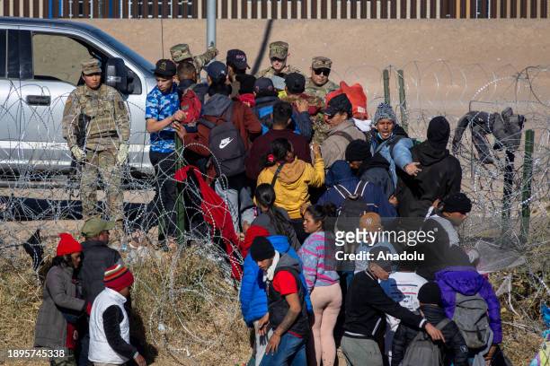 Texas National Guard hold migrants crossing the Rio Grande River to seek humanitarian asylum before crossing the United States border in Ciudad...