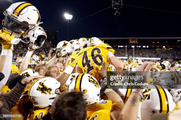 Place kicker John Hoyland of the Wyoming Cowboys celebrates with teammates after the Cowboys defeated the Toledo Rockets 16-15 during the Barstool...