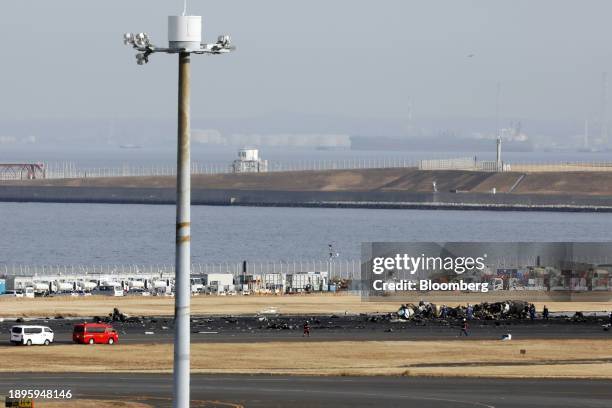 Officials investigate the wreckage of a De Havilland Canada Dash 8 aircraft operated by the Japan Coast Guard following a collision at Haneda Airport...