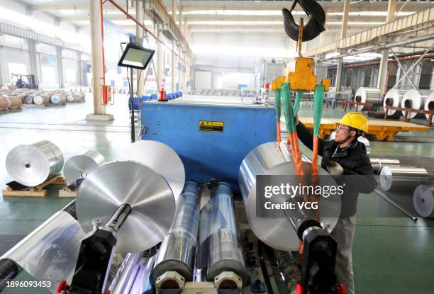 An employee works on the production line of aluminum foil at a workshop of Anhui Limu New Material Technology Co., Ltd on December 30, 2023 in Suixi...