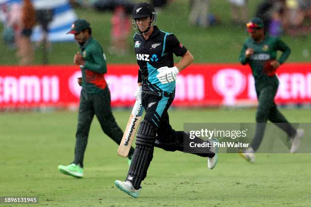 Mitchell Santner of New Zealand leaves the pitch as the rain arrive during game three of the Men's T20 International series between New Zealand and...